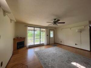 unfurnished living room featuring ceiling fan and hardwood / wood-style flooring