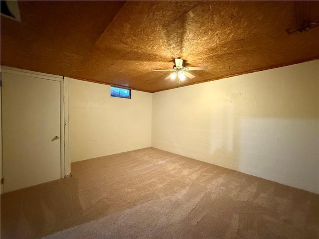 basement featuring ceiling fan, wooden ceiling, and carpet