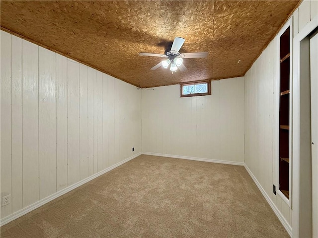 carpeted spare room with ceiling fan and wood ceiling