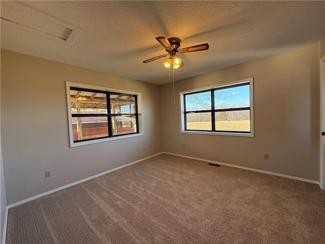 unfurnished room featuring carpet, visible vents, a textured ceiling, and baseboards