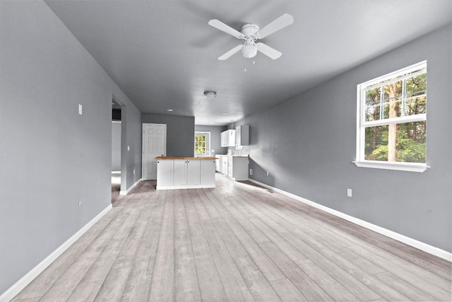 unfurnished living room featuring ceiling fan, plenty of natural light, and light hardwood / wood-style floors