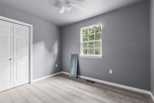 unfurnished bedroom featuring ceiling fan, a closet, and light hardwood / wood-style floors