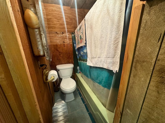 bathroom with tile patterned flooring, shower / bath combo with shower curtain, and toilet