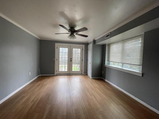 empty room featuring ceiling fan, french doors, ornamental molding, and light hardwood / wood-style flooring