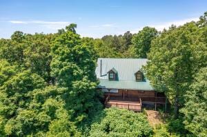 drone / aerial view featuring a wooded view