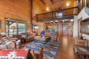 living area with wood walls, wood ceiling, high vaulted ceiling, and wood finished floors