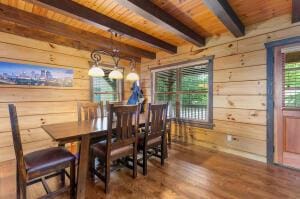 dining space featuring wooden ceiling, wood finished floors, beamed ceiling, and wood walls