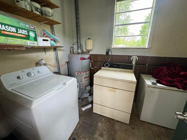 clothes washing area featuring independent washer and dryer and water heater