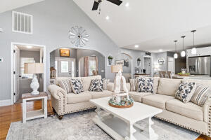 living room featuring light hardwood / wood-style floors, high vaulted ceiling, and ceiling fan