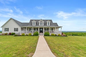 farmhouse inspired home featuring a porch and a front yard