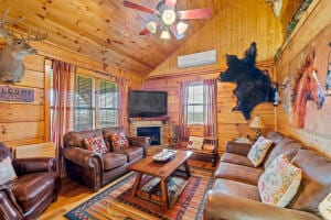 living room with hardwood / wood-style flooring, vaulted ceiling, and wood walls