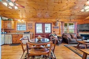 dining space with a wealth of natural light, wooden walls, lofted ceiling, and ceiling fan