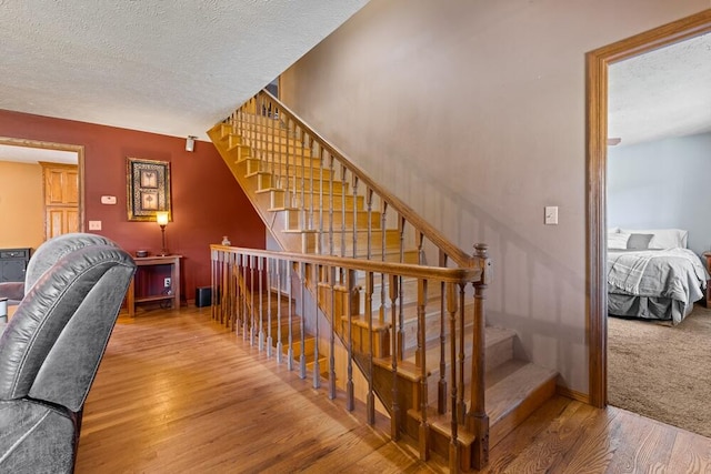 stairs featuring carpet floors and a textured ceiling