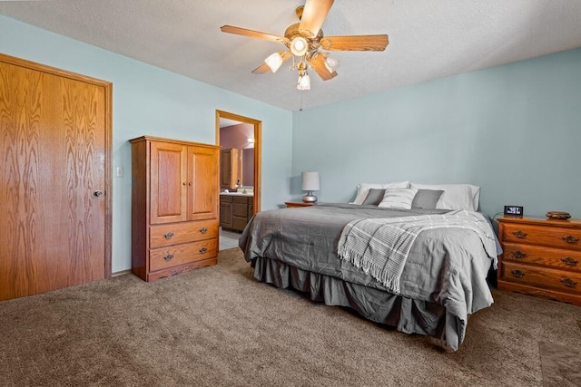 bedroom with carpet, a textured ceiling, ensuite bath, and ceiling fan