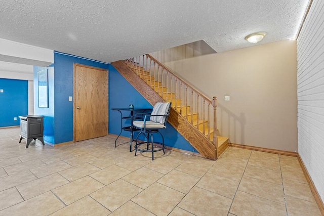 staircase featuring tile patterned floors and a textured ceiling