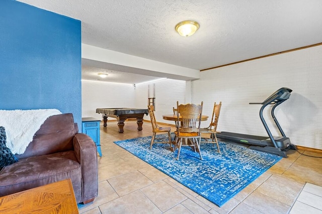 dining room featuring a textured ceiling, pool table, crown molding, and light tile patterned floors