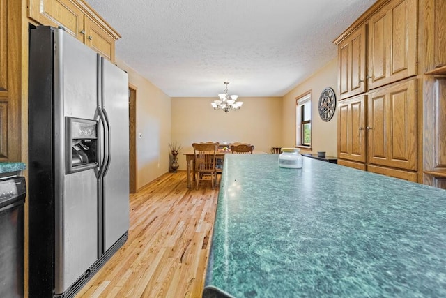 kitchen featuring dishwasher, a chandelier, light wood-type flooring, a textured ceiling, and stainless steel fridge