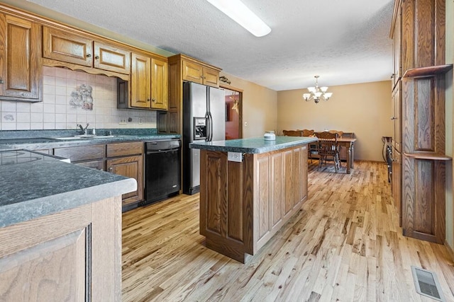 kitchen with backsplash, a center island, light wood-type flooring, dishwasher, and stainless steel fridge