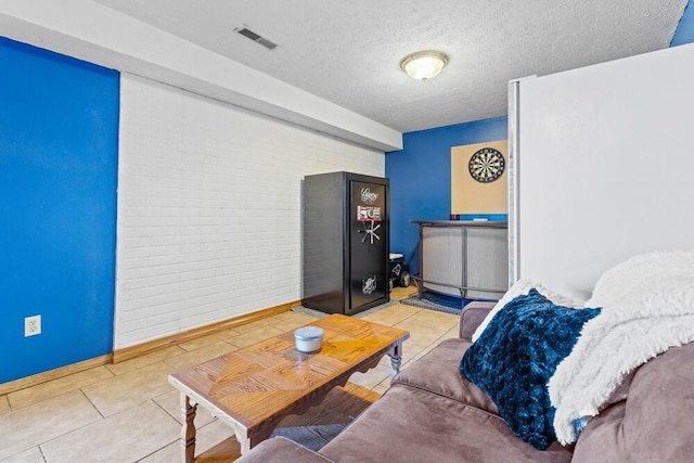 tiled living room featuring a textured ceiling