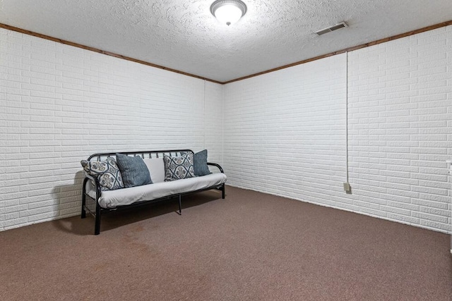 living area with a textured ceiling, carpet floors, and crown molding