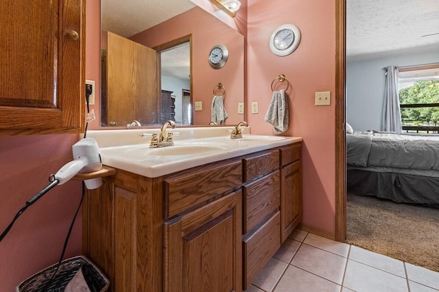 bathroom with a textured ceiling, vanity, and tile patterned floors