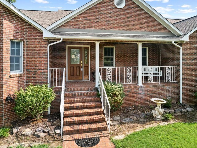 view of exterior entry with covered porch