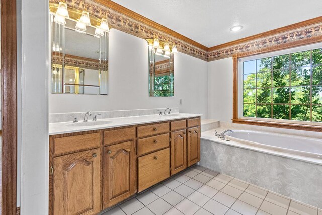 bathroom featuring tile patterned flooring, a tub, vanity, and ornamental molding