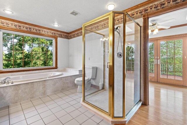 bathroom with ceiling fan, independent shower and bath, toilet, and a textured ceiling