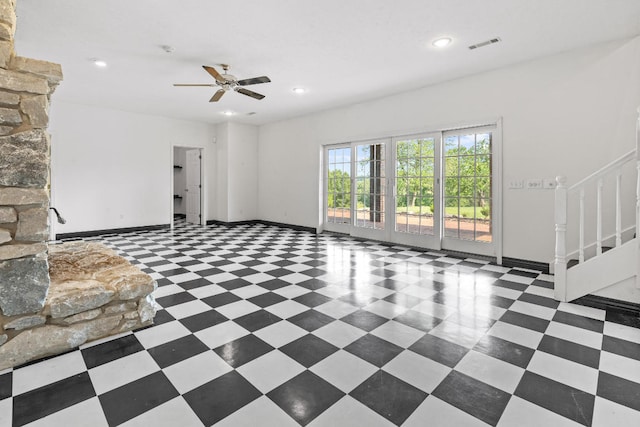 unfurnished living room featuring dark tile patterned flooring and ceiling fan