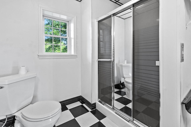 bathroom featuring toilet, walk in shower, and tile patterned floors