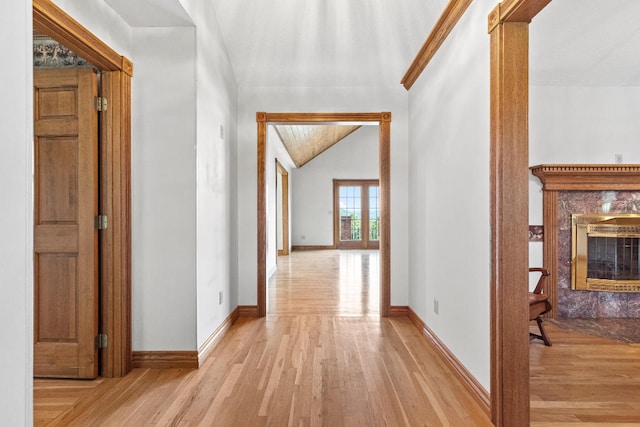 hall with decorative columns and light wood-type flooring