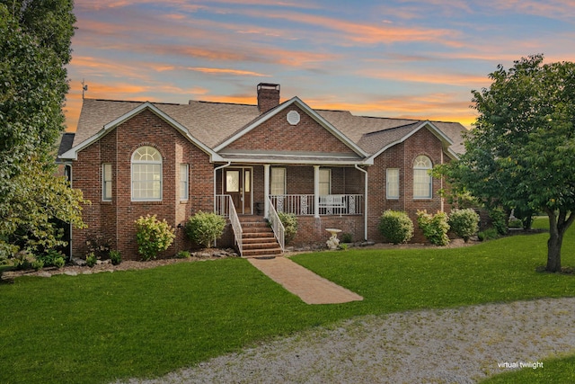 view of front facade with a lawn and covered porch