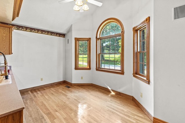 unfurnished dining area with ceiling fan, light hardwood / wood-style flooring, and lofted ceiling with beams