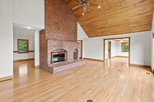 unfurnished living room with ceiling fan, light wood-type flooring, high vaulted ceiling, a brick fireplace, and wooden ceiling