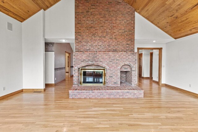 unfurnished living room with light hardwood / wood-style flooring, brick wall, high vaulted ceiling, wood ceiling, and a brick fireplace