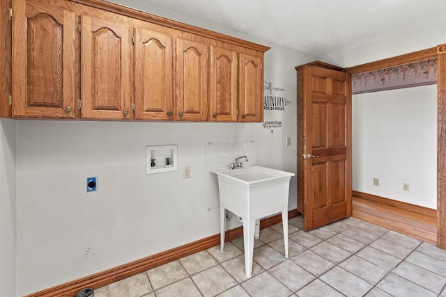 clothes washing area featuring light hardwood / wood-style floors, hookup for an electric dryer, cabinets, and hookup for a washing machine