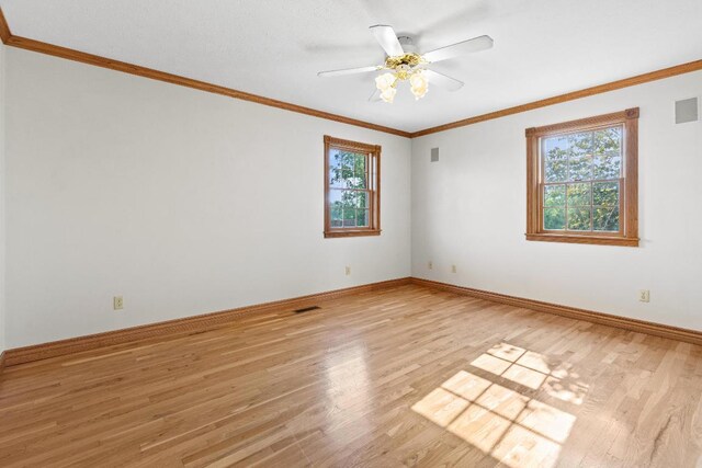 empty room with light hardwood / wood-style floors, ornamental molding, and ceiling fan