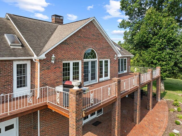 rear view of property featuring a wooden deck and french doors