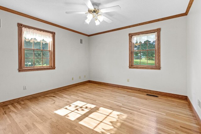 empty room featuring ceiling fan, light hardwood / wood-style floors, a healthy amount of sunlight, and crown molding