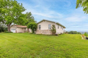 view of side of property featuring a garage and a lawn