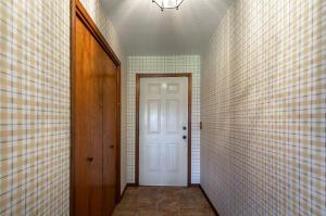 doorway to outside featuring wallpapered walls