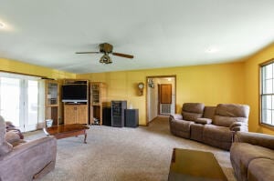 carpeted living room featuring ceiling fan