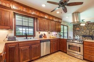 kitchen featuring a sink, stainless steel appliances, island exhaust hood, and a healthy amount of sunlight