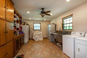 clothes washing area with ceiling fan, light tile patterned flooring, and washer and clothes dryer