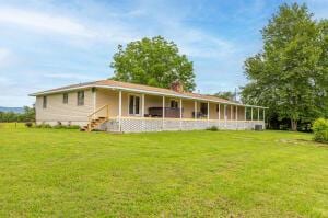 rear view of property with a yard