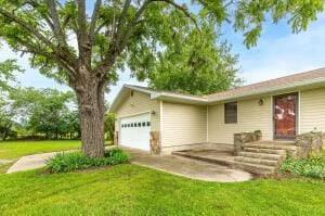 ranch-style house featuring a front lawn and an attached garage