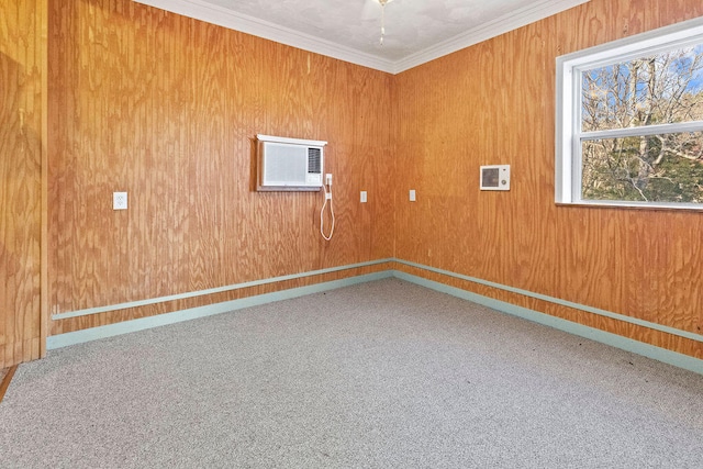 spare room featuring an AC wall unit, wooden walls, carpet floors, and crown molding