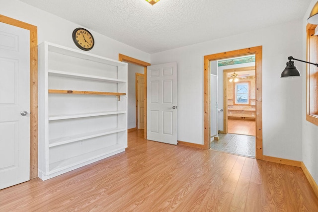 unfurnished bedroom featuring light wood-type flooring and a textured ceiling