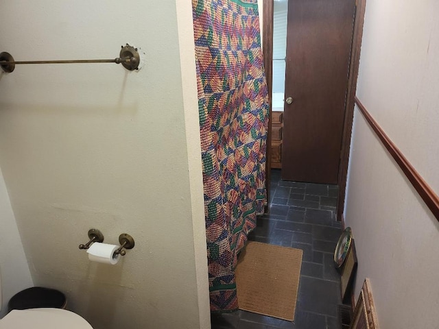 bathroom with toilet and a shower with curtain