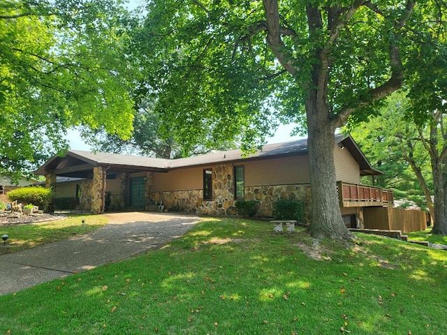 view of front of home with a front lawn, a deck, and a carport